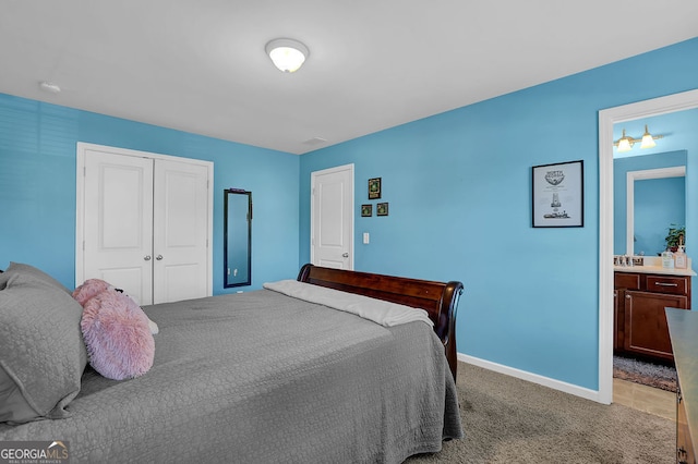 bedroom with ensuite bathroom, a closet, and carpet floors