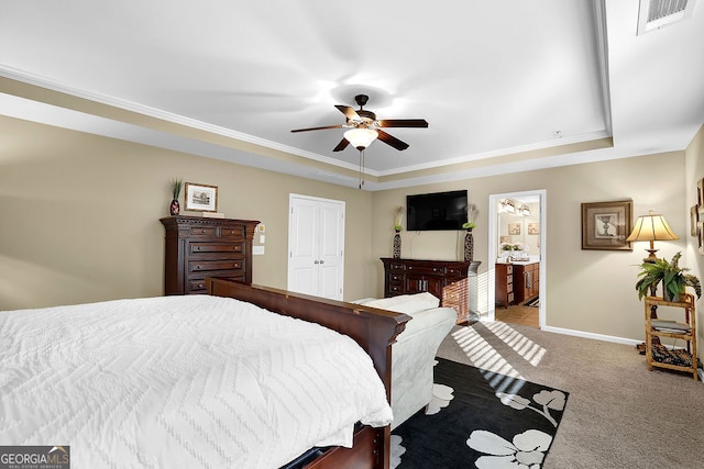 carpeted bedroom with a closet, ensuite bath, ceiling fan, and crown molding