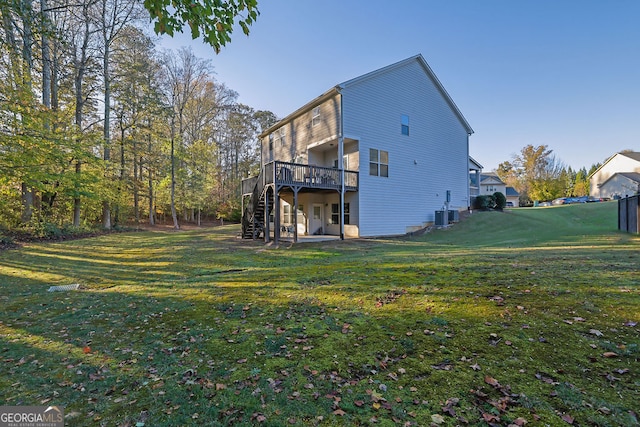 back of house featuring a deck, central AC unit, a patio area, and a lawn