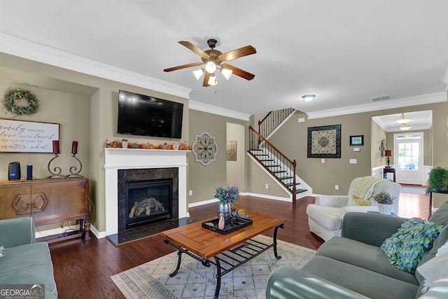 living room featuring hardwood / wood-style flooring, ceiling fan, ornamental molding, and a premium fireplace