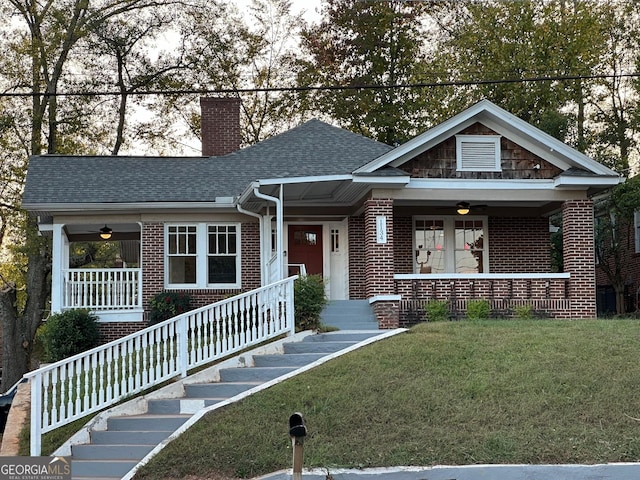 view of front facade with a front lawn, ceiling fan, and covered porch