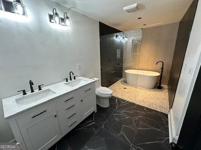 bathroom with a tub to relax in, toilet, and vanity