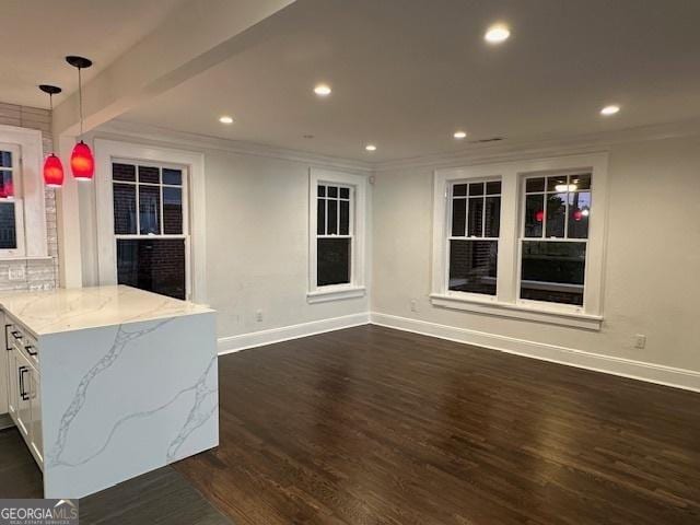 interior space featuring pendant lighting, dark wood-type flooring, white cabinetry, beam ceiling, and light stone counters