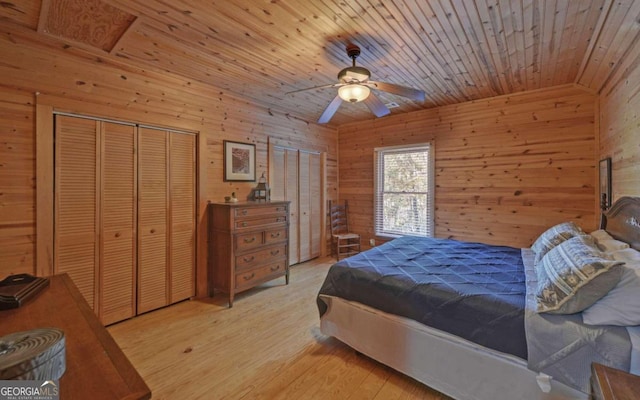 bedroom with wood walls, light hardwood / wood-style flooring, ceiling fan, wood ceiling, and a closet