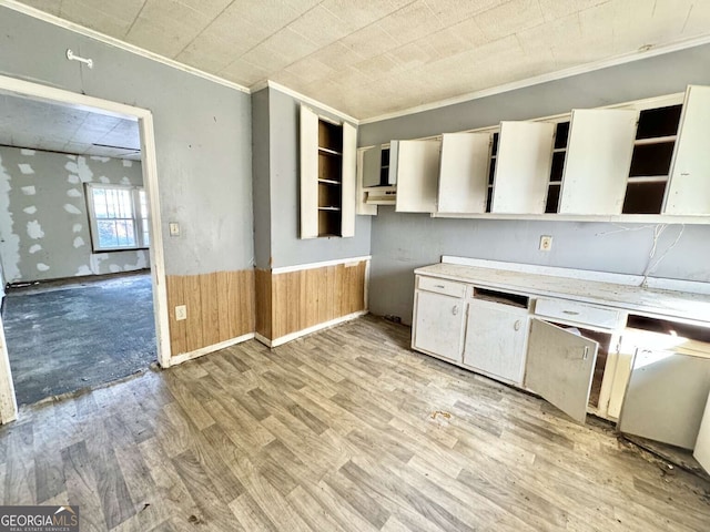 kitchen with wood walls, light hardwood / wood-style flooring, and crown molding