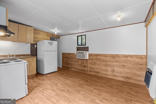 kitchen featuring wood walls, light brown cabinets, white appliances, light hardwood / wood-style floors, and heating unit