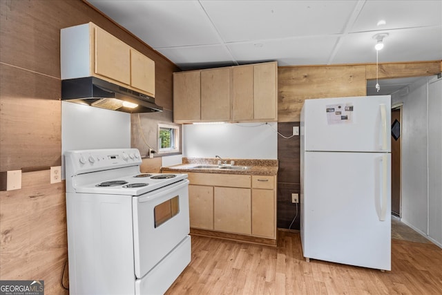 kitchen featuring light brown cabinets, white appliances, sink, wooden walls, and light hardwood / wood-style flooring