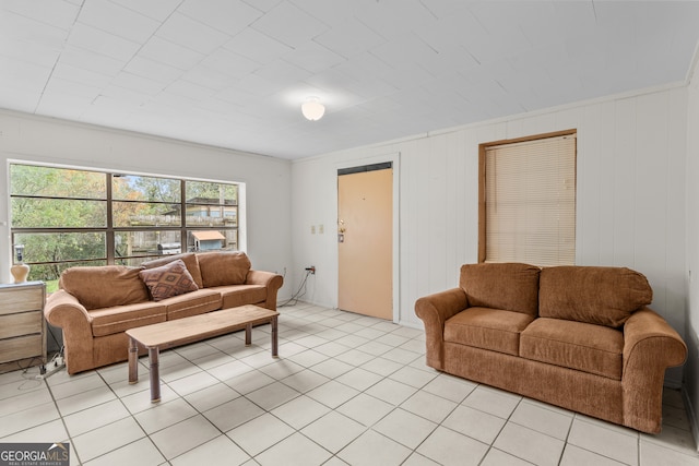 living room featuring light tile patterned floors, crown molding, and wood walls