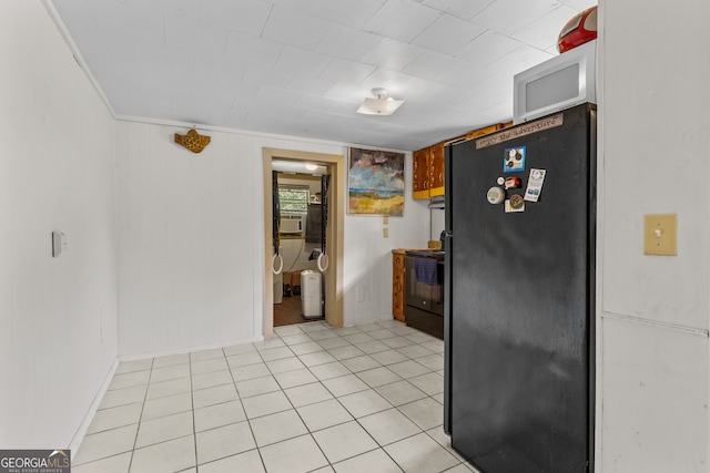 kitchen featuring cooling unit, light tile patterned flooring, black appliances, and ornamental molding