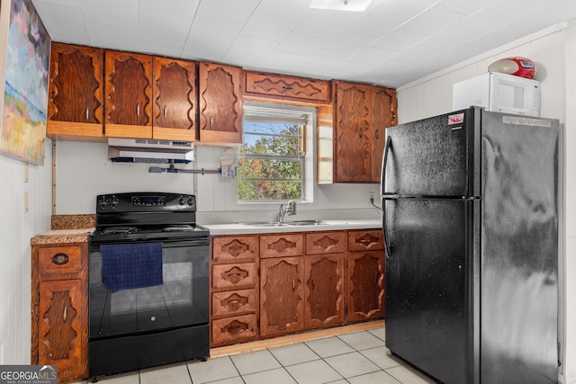 kitchen featuring light tile patterned flooring, sink, and black appliances