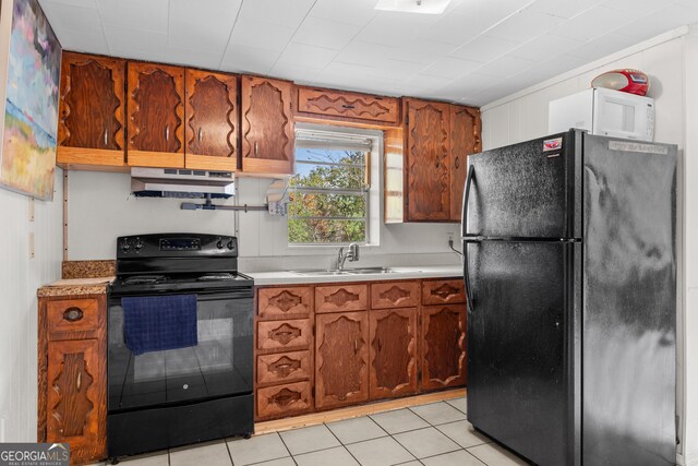650 Mccharles St, Dalton, GA 30720 - kitchen with black appliances, a sink, under cabinet range hood, light countertops, and brown cabinetry