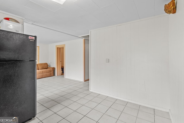 interior space featuring light tile patterned floors and wooden walls