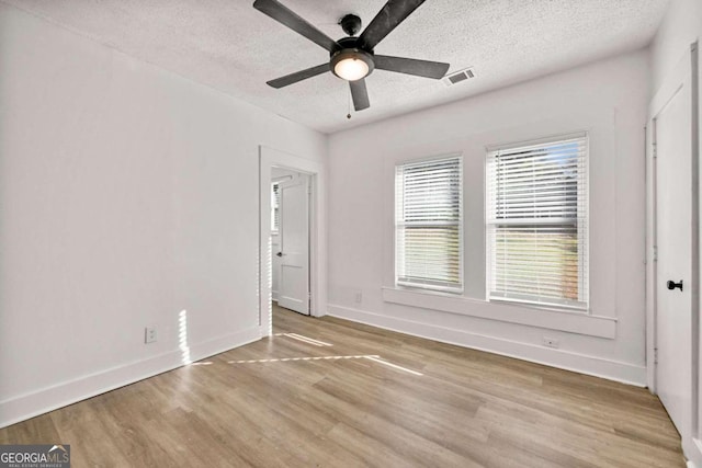 unfurnished bedroom with ceiling fan, a textured ceiling, and light wood-type flooring