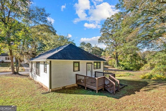 rear view of property featuring a lawn and a wooden deck