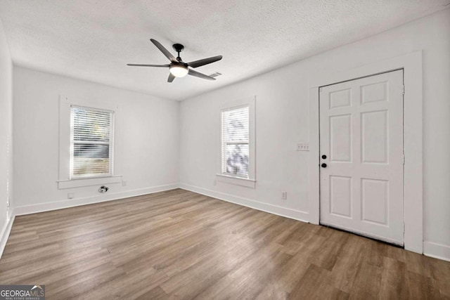 unfurnished room featuring wood-type flooring, a textured ceiling, and ceiling fan