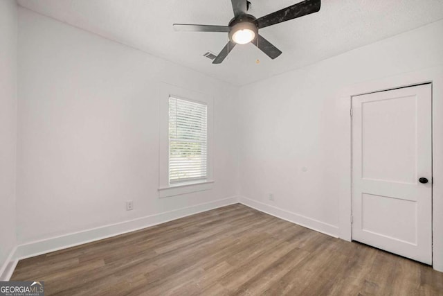 empty room featuring wood-type flooring, a textured ceiling, and ceiling fan