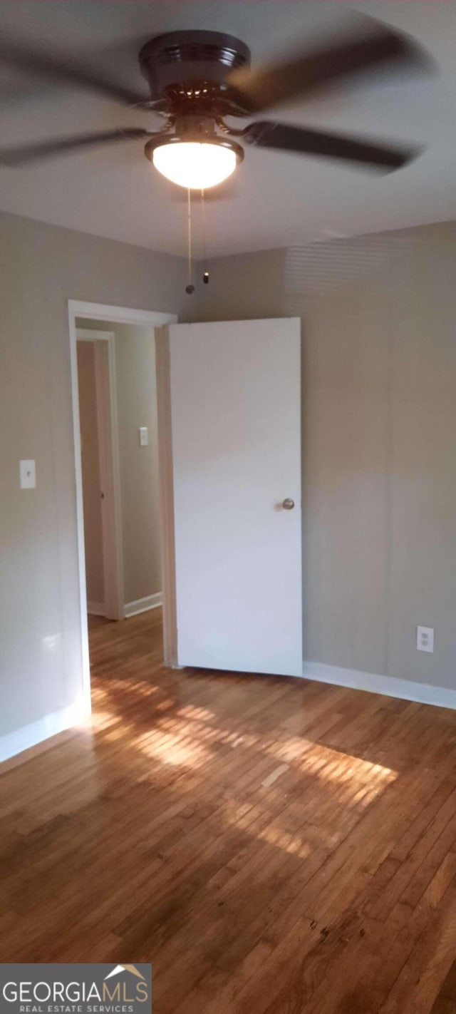 spare room featuring ceiling fan and hardwood / wood-style flooring