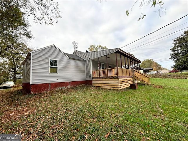 exterior space featuring a wooden deck and a front lawn