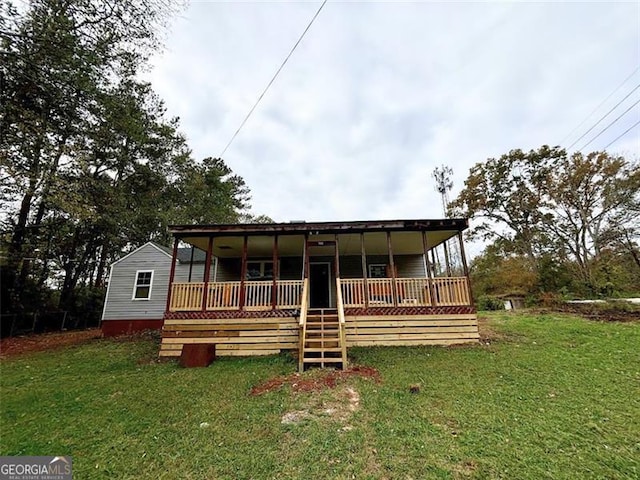 back of property with a lawn and covered porch