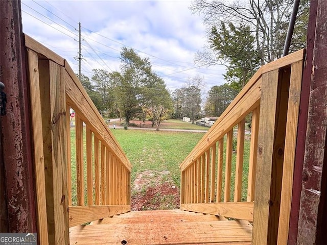 wooden deck featuring a lawn