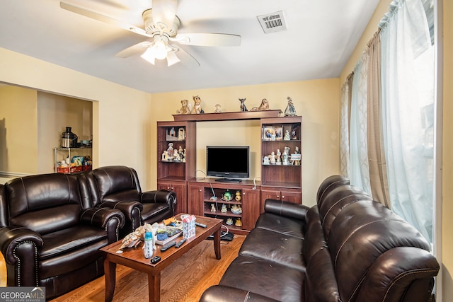 living room with wood-type flooring and ceiling fan