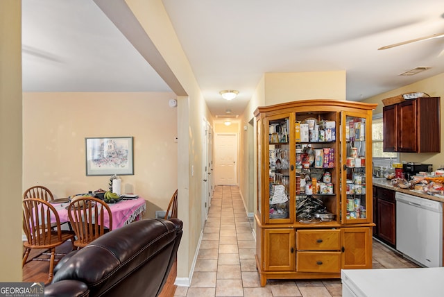 kitchen with stainless steel dishwasher and light tile patterned floors