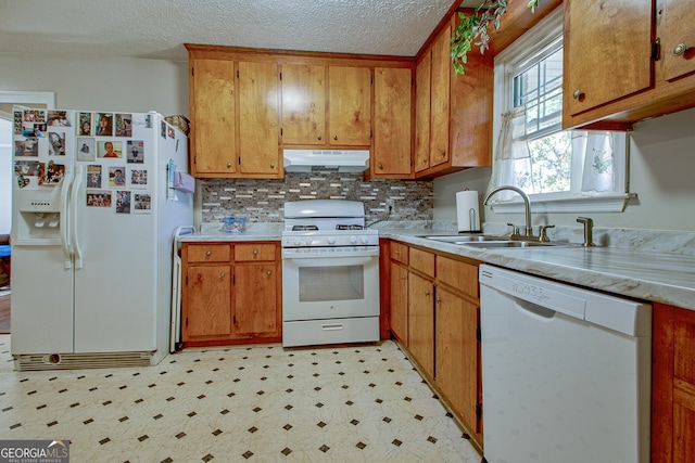 kitchen with backsplash, sink, a textured ceiling, and white appliances