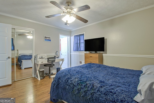 bedroom featuring ceiling fan, crown molding, a textured ceiling, a closet, and hardwood / wood-style flooring