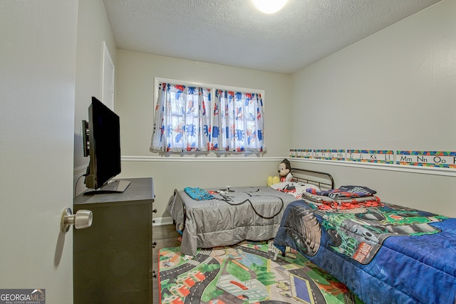 bedroom featuring hardwood / wood-style flooring and a textured ceiling