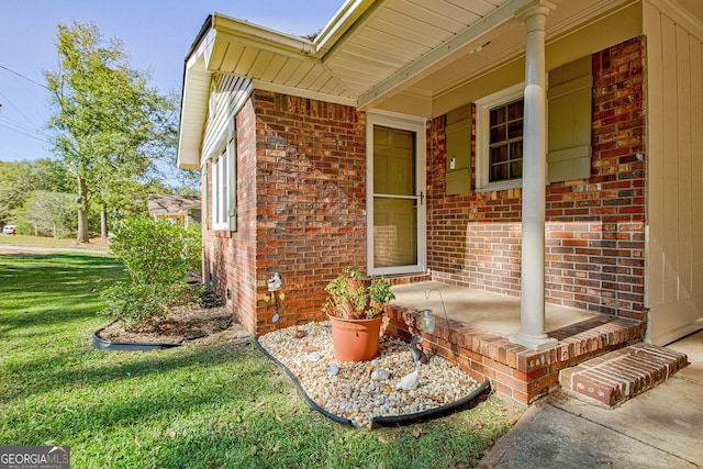 doorway to property featuring a lawn and a porch