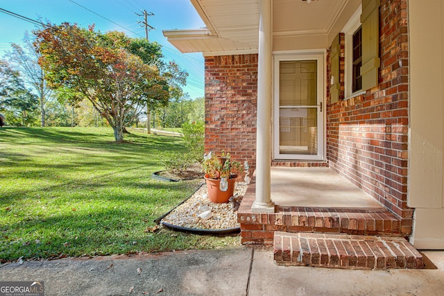 view of exterior entry featuring a lawn