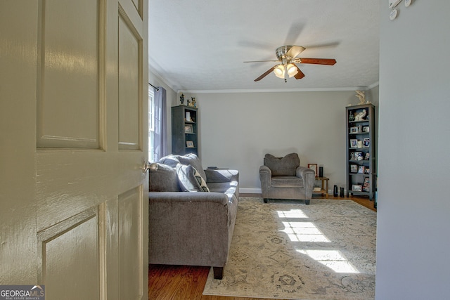 living room with hardwood / wood-style flooring, ceiling fan, and ornamental molding