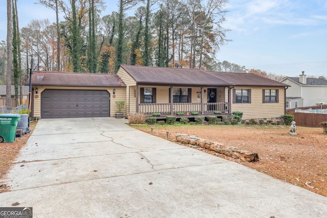 ranch-style house featuring covered porch and a garage