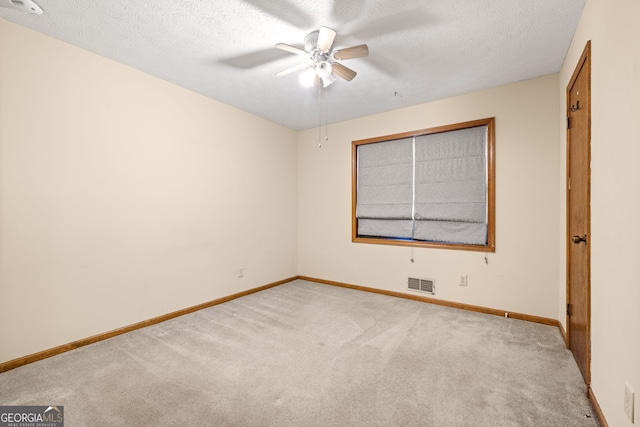 carpeted empty room featuring ceiling fan and a textured ceiling