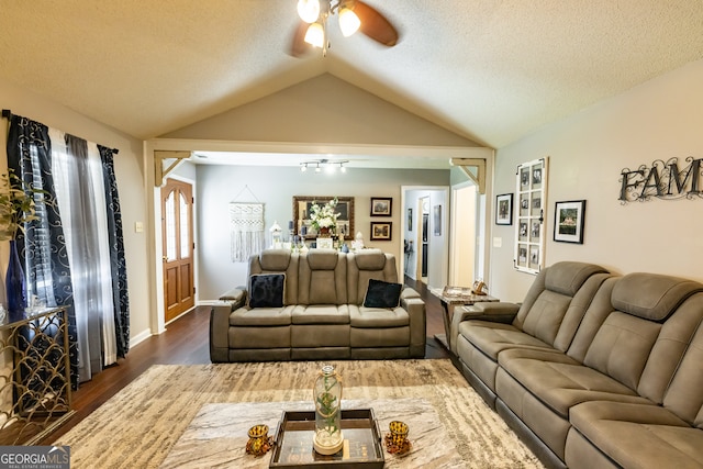 living room with a textured ceiling, ceiling fan, dark hardwood / wood-style floors, and vaulted ceiling