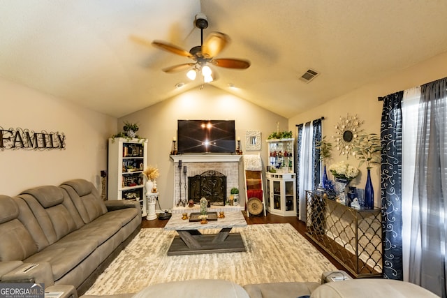 living room with a fireplace, hardwood / wood-style flooring, ceiling fan, and lofted ceiling