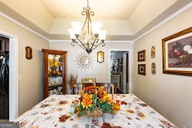 dining space featuring a tray ceiling, an inviting chandelier, and crown molding