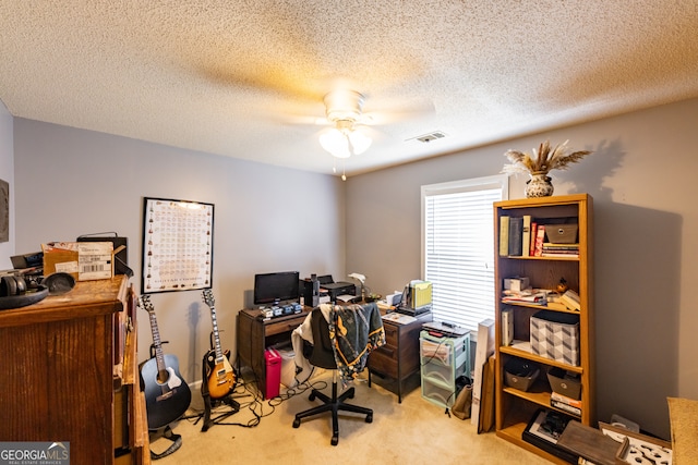 carpeted office featuring a textured ceiling and ceiling fan