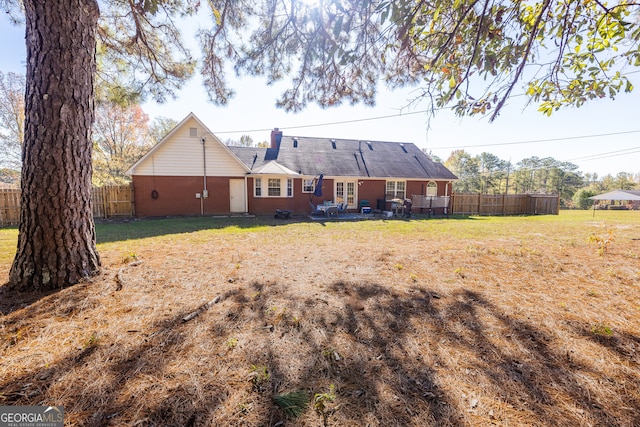 back of property featuring a lawn and a patio area