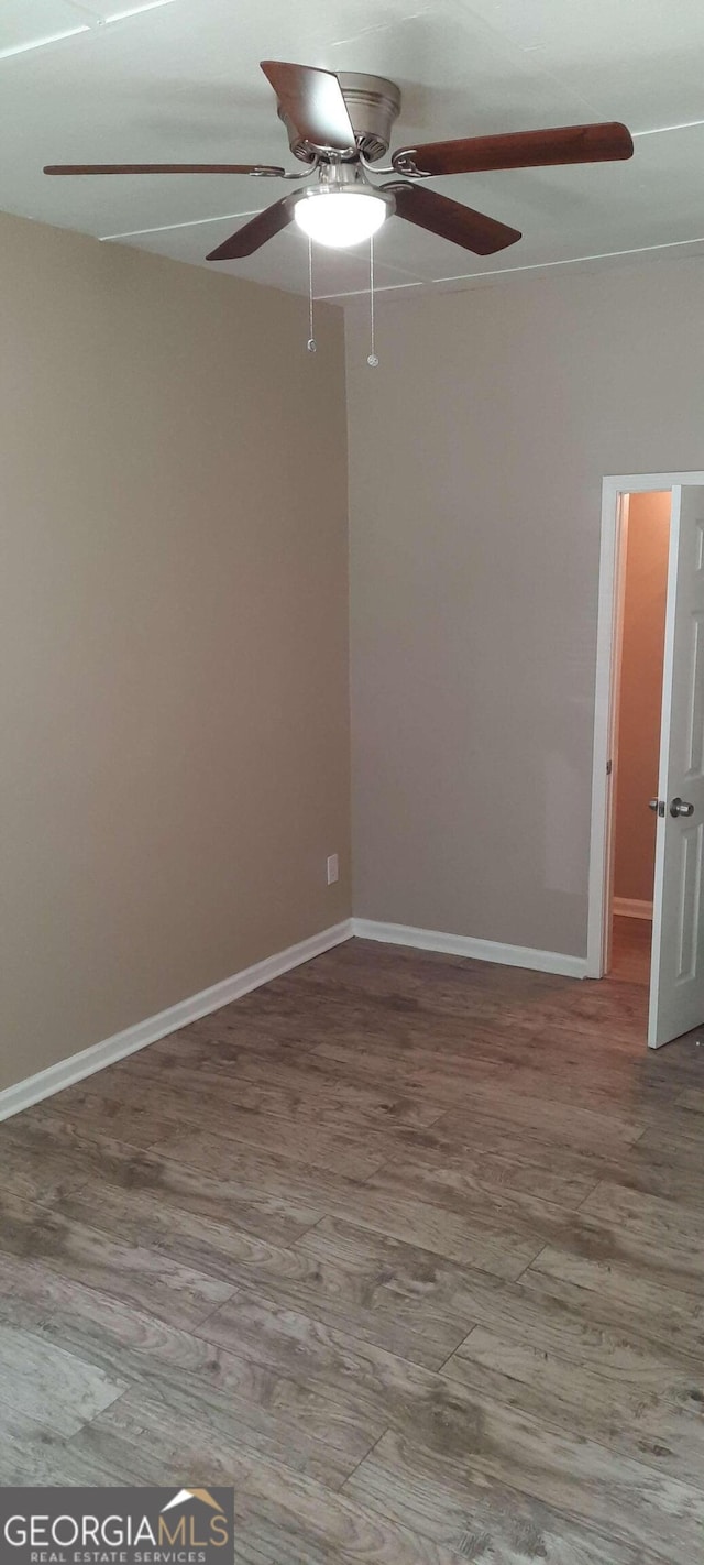 empty room with hardwood / wood-style floors and ceiling fan