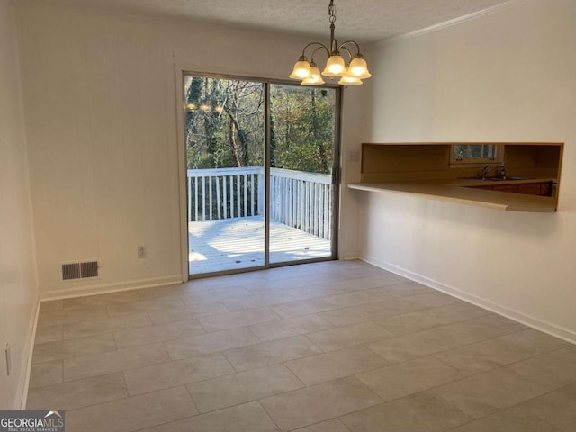 unfurnished dining area featuring light tile patterned floors, ornamental molding, a textured ceiling, and an inviting chandelier