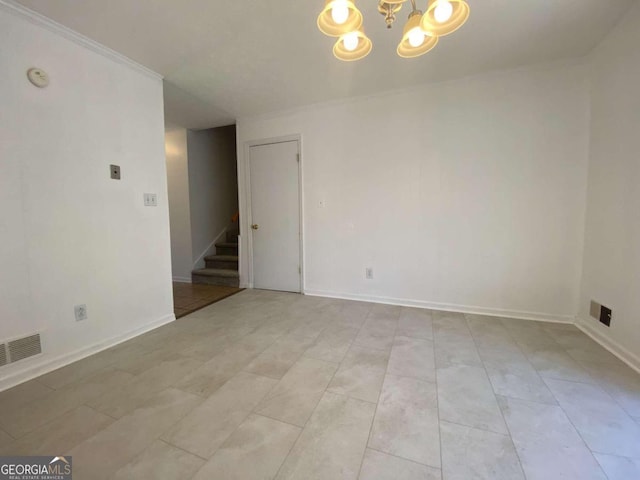 empty room with ornamental molding and a notable chandelier