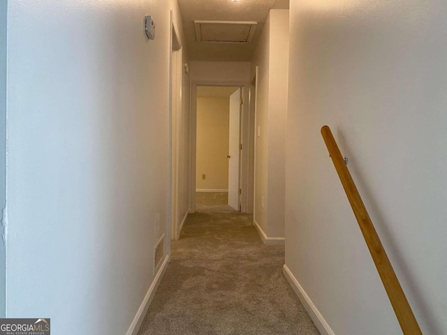 corridor with carpet floors and a textured ceiling