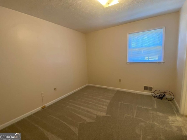 unfurnished room featuring a textured ceiling and carpet floors