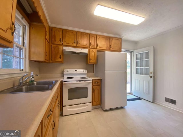 kitchen featuring a textured ceiling, white appliances, and sink