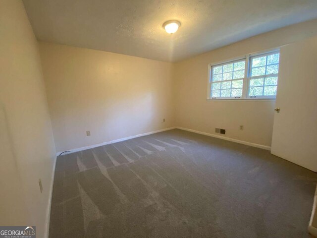 carpeted spare room featuring a textured ceiling