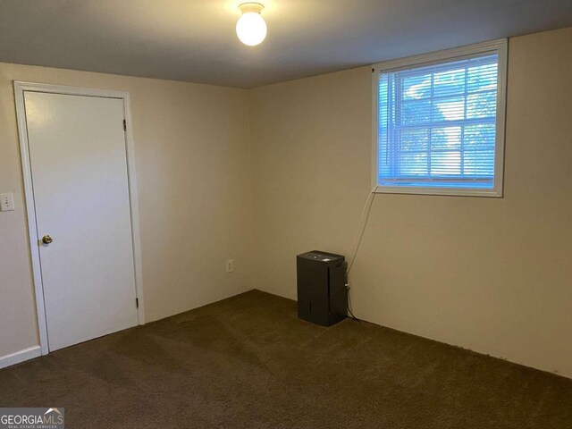 empty room with dark colored carpet