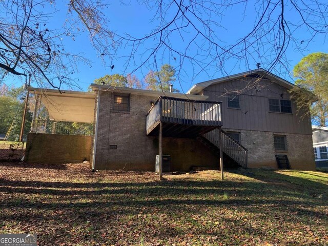 back of house with a lawn and a wooden deck