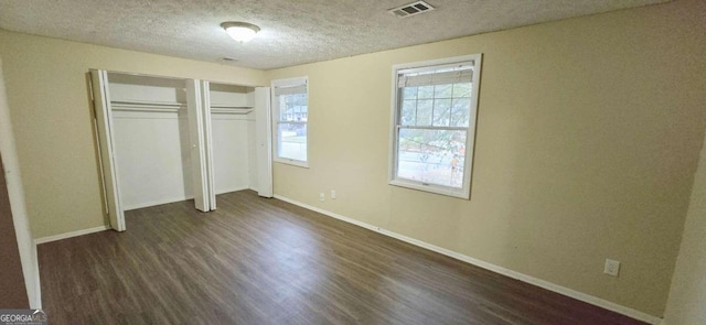 unfurnished bedroom featuring dark hardwood / wood-style floors and a textured ceiling