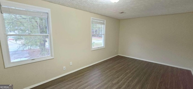 unfurnished room featuring dark hardwood / wood-style flooring and a textured ceiling